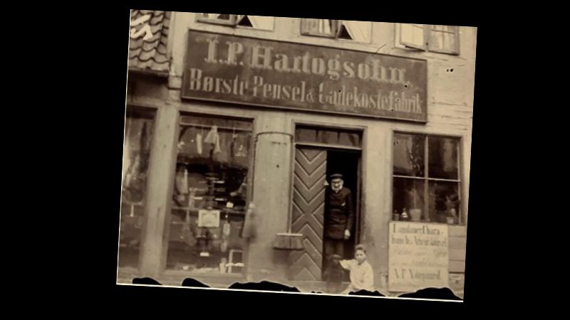 Jonas Philip Hartogsohn i døren til sin børstenbinderforretning i Snaregade i Randers. Fotografi fra omkring år 1900. Foto: Randers Stadsarkiv, Hartogsohn-samlingen.